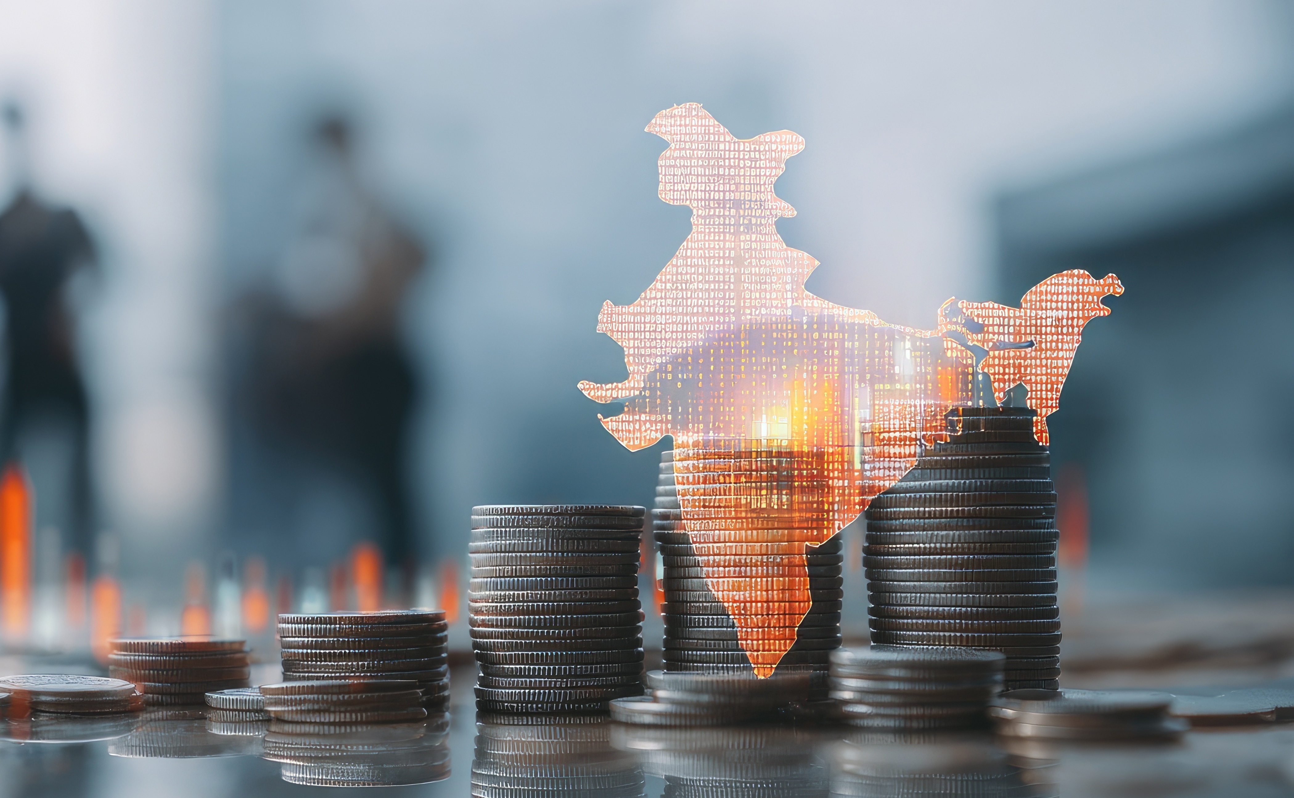 Coins stacked in ascending order with image of India country outline and chart lines. 