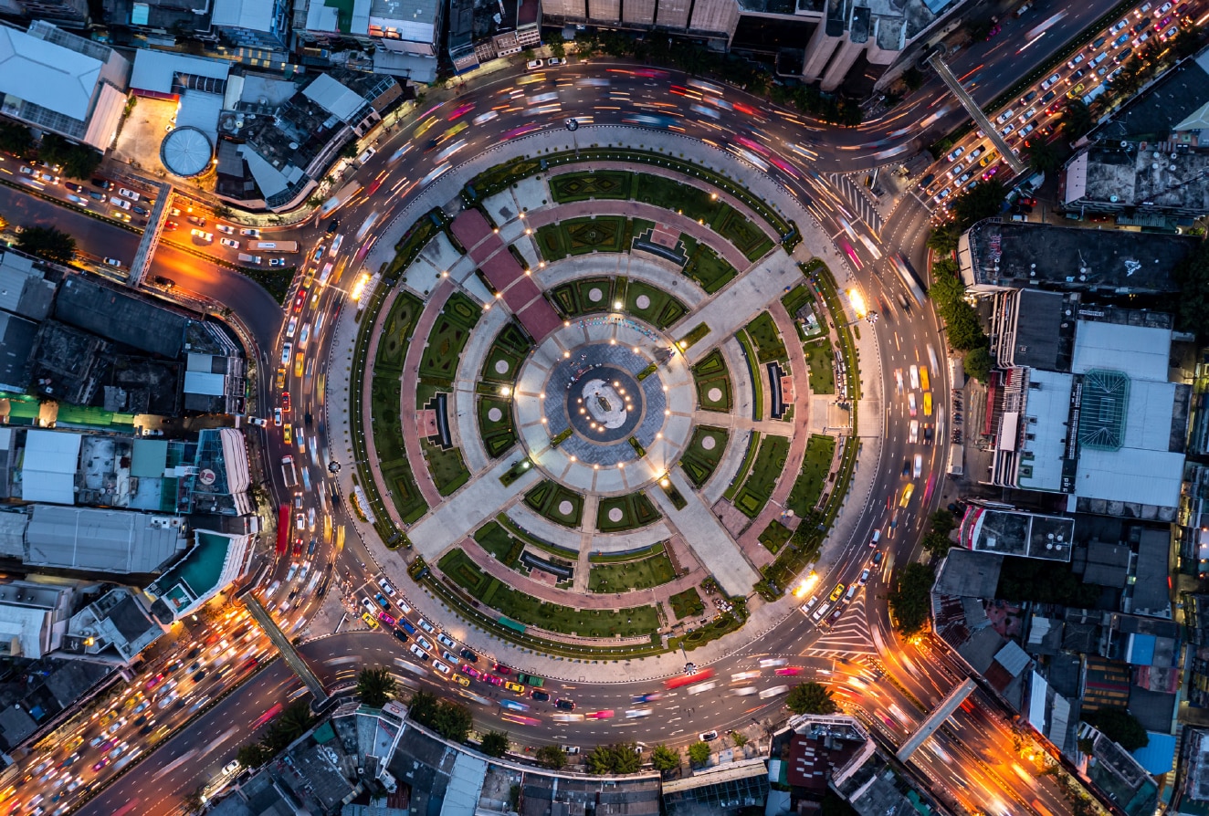 Arial view of city center with cars driving around it.
