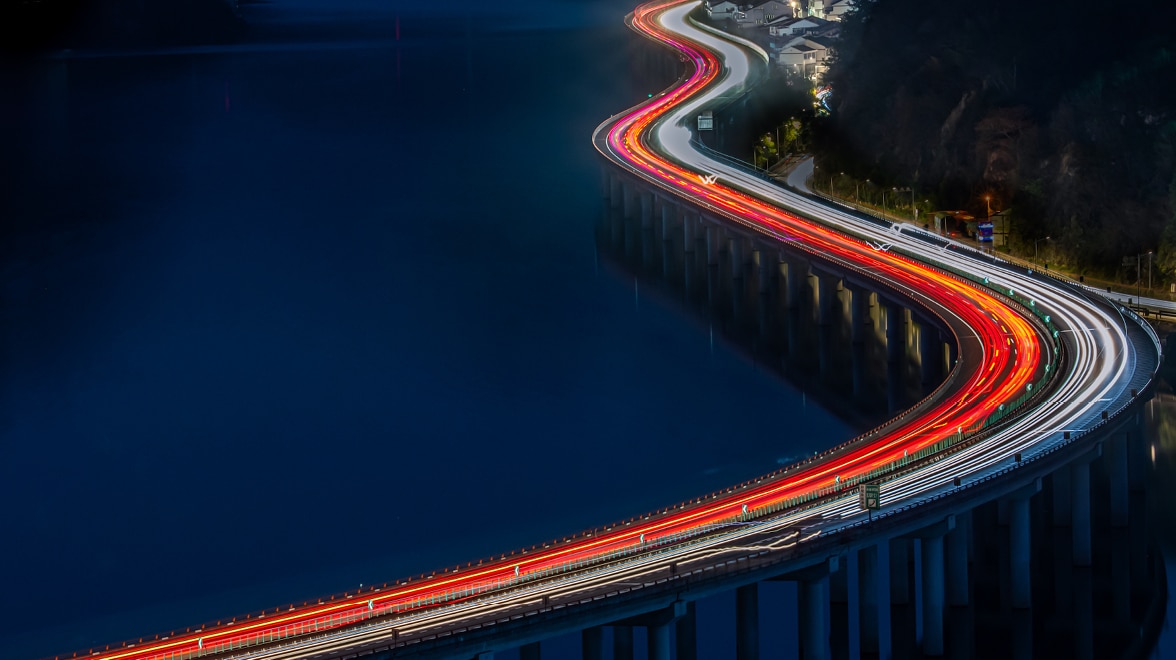 Bridge with fast moving cars at night.