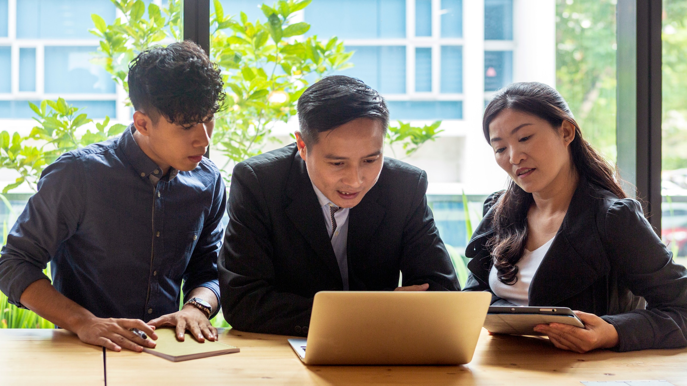 Three people around a computer