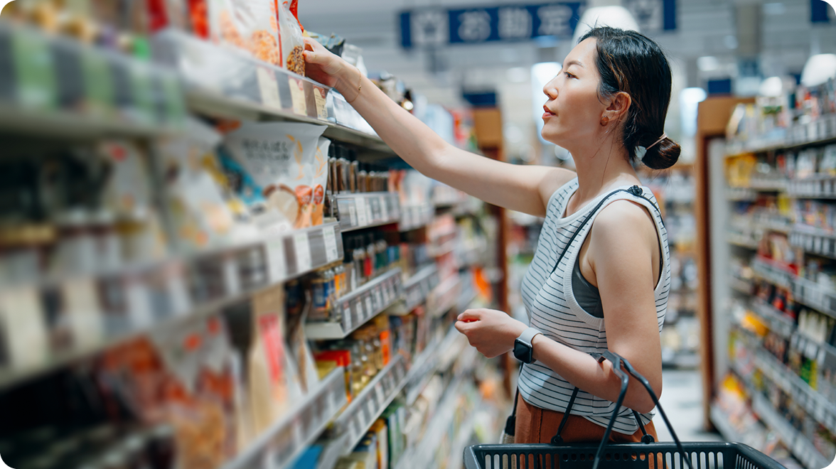 woman grocery shopping grabbing something from aisle