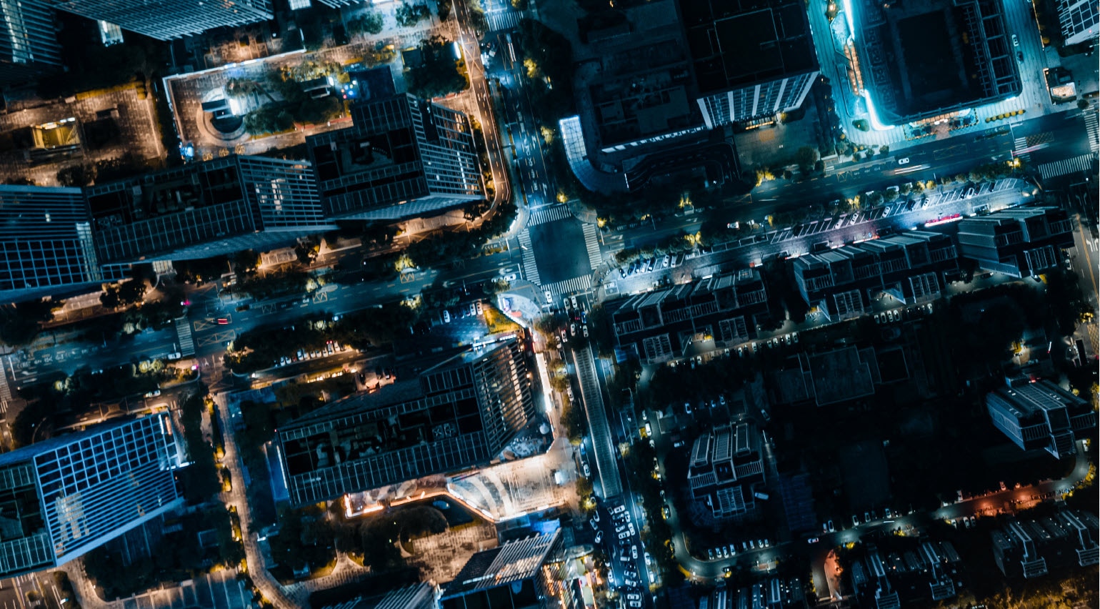 birds eye view of city at night with buildings and street lights