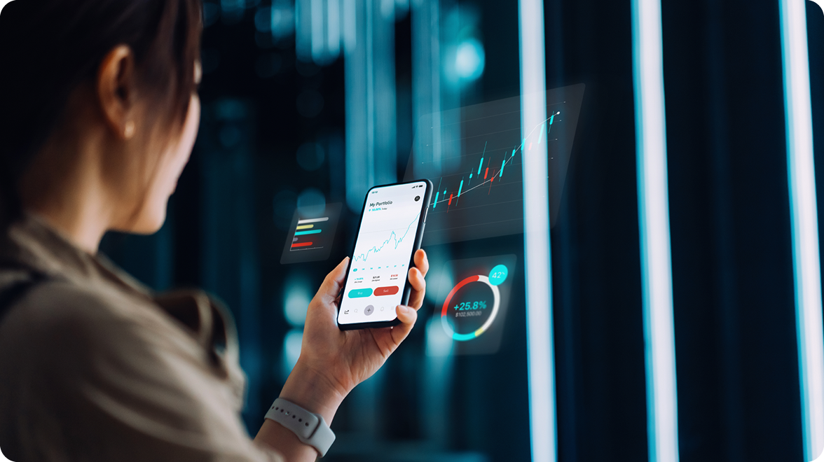 Person holding a smartphone displaying investment portfolio data, with digital financial charts and data visualizations in the background.