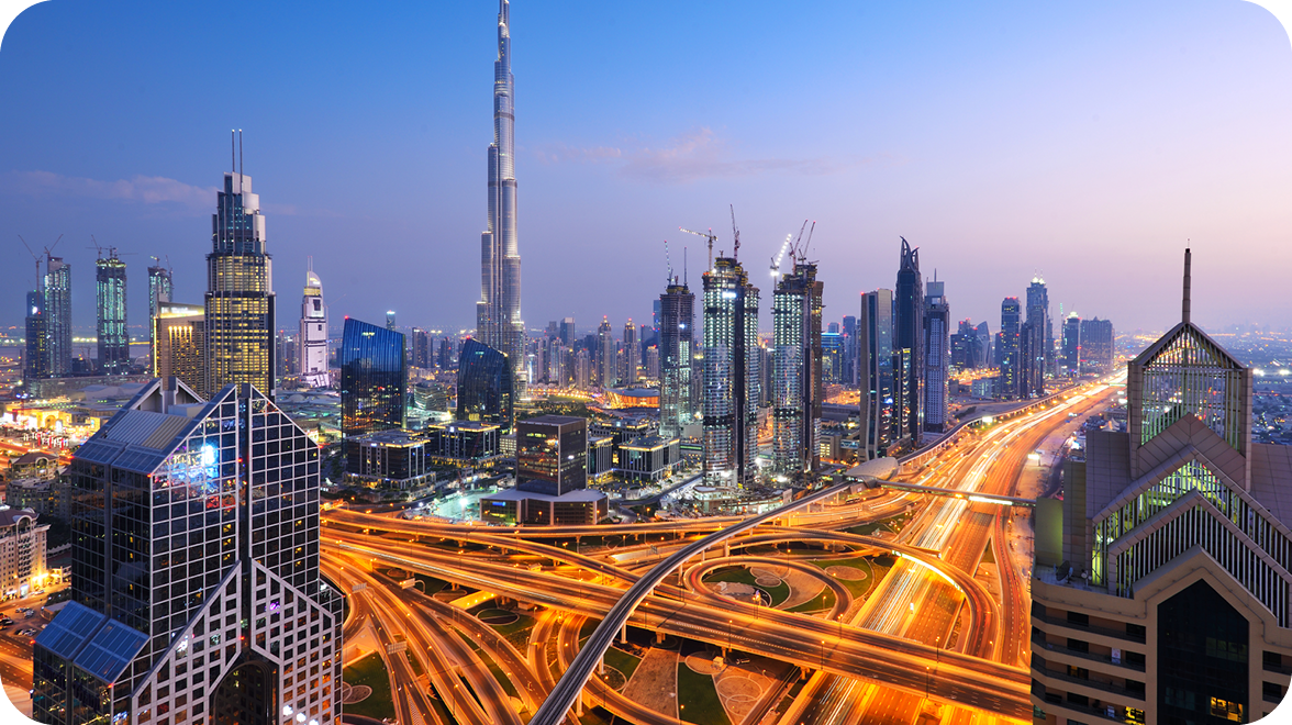 Dubai skyline with the Burj Khalifa and illuminated highways at dusk.